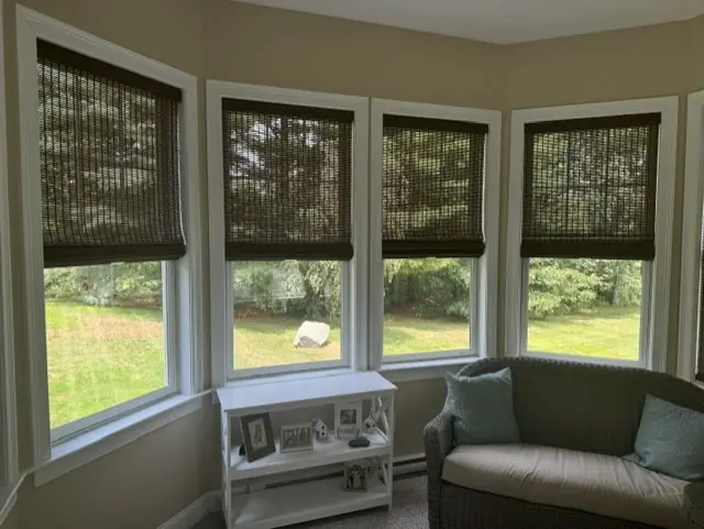 Woven wood shades on a bay window overlooking the yard