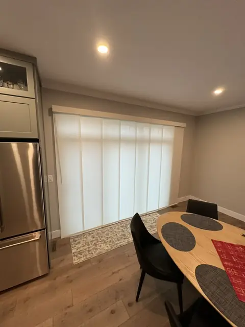 Sliding panel shades drawn across a kitchen patio door