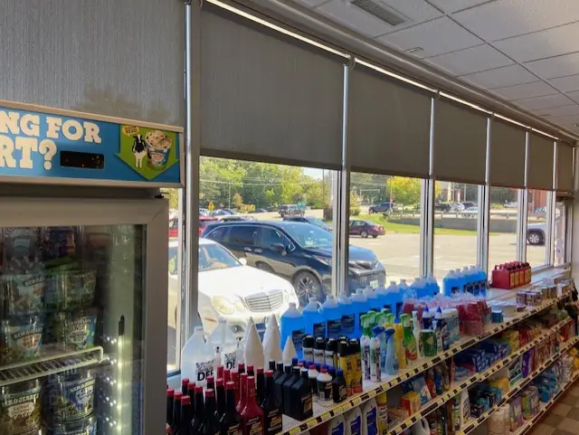 Roller shades along the storefront windows of a convenience store