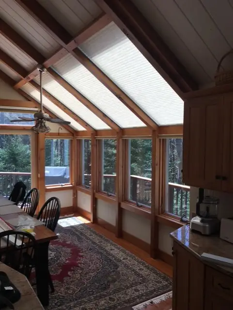 Sunroom with shaded skylights in a peaked wood ceiling